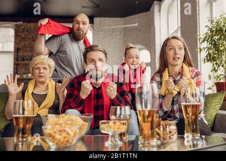 Aufgeregt, glücklich, die große Familie beim Fußball, Fußball, Basketball, Hockey, Tennis, Rugbyspiel auf der Couch zuhause beobachtet. Fans emotional jubeln für Lieblings-Nationalmannschaft. Sport, TV, Meisterschaft. Stockfoto