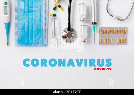 Schutzmasken, Medikamente, Thermometer, Stethoskop und Spritze mit Coronavirus-Text auf weißem Hintergrund. Roman Coronavirus 2019-nCoV, MERS-Cov m Stockfoto