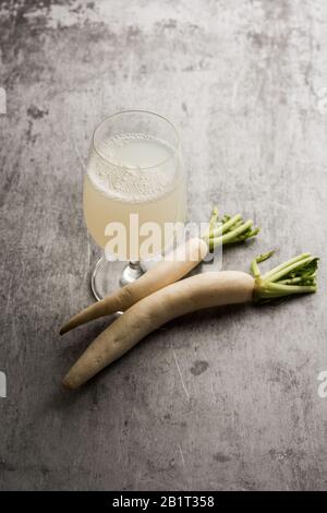 Gesunder frischer Daikon-Saft oder Mooli-Extrakt trinken Sie in einem Glas mit rohem Maultier Stockfoto