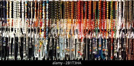 Rosaries in verschiedenen Farben und Größen, die auf den Boden gefallen sind. Es kann für die Anforderungen der islamischen Religion oder als Zubehör verwendet werden. Stockfoto