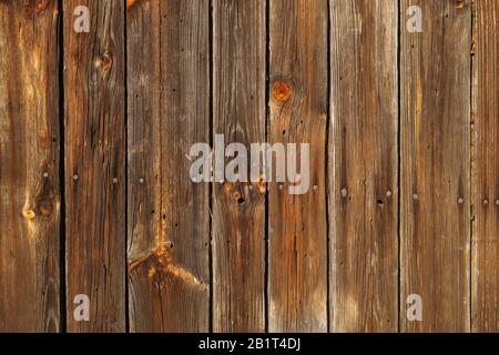 Hintergrund. Eine Wand aus alten Bohlen, die durch Nägel verbunden sind. Stockfoto