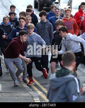 Boys tussle für den Lederball während der jährlichen Jedburgh BA' Game Event auf Jedburgh's High Street in the Scottish Borders.Bilddatum: Donnerstag, 27. Februar 2020. Die jährliche Veranstaltung begann in den 1700er Jahren und das erste Spiel überhaupt wurde angeblich mit einem Engländer Kopf gespielt. Es beinhaltet zwei Teams, die Uppies (Bewohner aus dem oberen Teil von Jedburgh) und die Doonies (Bewohner aus dem unteren Teil von Jedburgh) bekommen den Ball entweder auf der Oberseite oder Unterseite der Stadt. Der Ball, der aus Leder, gefüllt mit Stroh und verziert mit Bändern, die Haare, wird in die geworfen Stockfoto