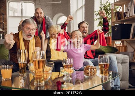 Aufgeregt, glücklich, die große Familie beim Fußball, Fußball, Basketball, Hockey, Tennis, Rugbyspiel auf der Couch zuhause beobachtet. Fans emotional jubeln für Lieblings-Nationalmannschaft. Sport, TV, Meisterschaft. Stockfoto