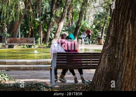Junges Paar auf einer Parkbank in Málaga, Spanien Stockfoto