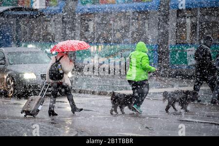 27. Februar 2020, Bayern, München: Passanten überqueren bei starkem Schneefall eine Straße. Foto: Sven Hoppe / dpa Stockfoto
