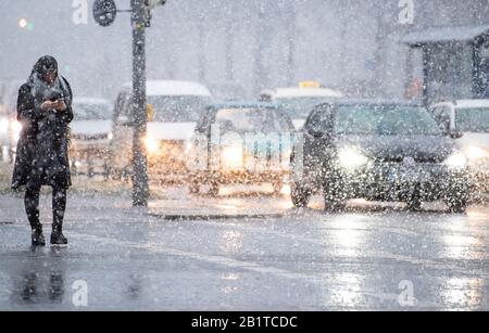 27. Februar 2020, Bayern, München: Eine Frau überquert bei starkem Schneefall eine Straße. Foto: Sven Hoppe / dpa Stockfoto
