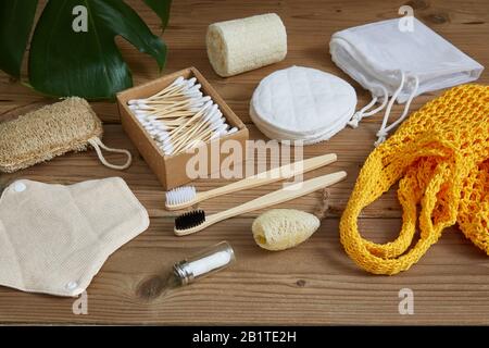 Das Konzept des Umweltbewusstseins. ECO-Produkte auf flachem Holzhintergrund. Ein Saitenbeutel, persönliche Hygieneartikel, eine Holzzahnbürste, ein Klo Stockfoto