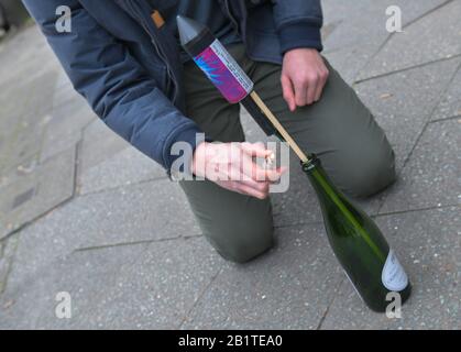 Start einer Silvesterrakete aus einer Flasche Stockfoto