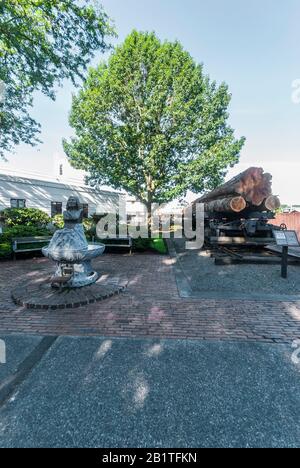 Skulptierte Büste des Chief Seattle Fountain und ein Eisenbahnwagen mit Holzstämmen in Renton, Washington. Die Büste wurde im Jahr 1909 von der Gorham Company gegossen. Stockfoto