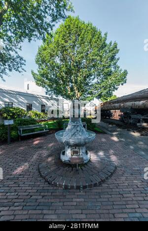 Skulptierte Büste des Chief Seattle Fountain und ein Eisenbahnwagen mit Holzstämmen in Renton, Washington. Die Büste wurde im Jahr 1909 von der Gorham Company gegossen. Stockfoto