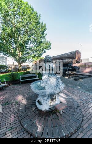 Skulptierte Büste des Chief Seattle Fountain und ein Eisenbahnwagen mit Holzstämmen in Renton, Washington. Die Büste wurde im Jahr 1909 von der Gorham Company gegossen. Stockfoto