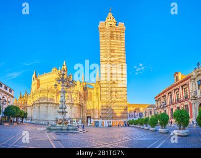 Sevilla, SPANIEN - 1. OKTOBER 2019: Die alte Plaza Virgen de los Reyes mit dem Wahrzeichen der Stadt, der Kathedrale mit hoher Giralda (Kirchturm), auf Oc Stockfoto