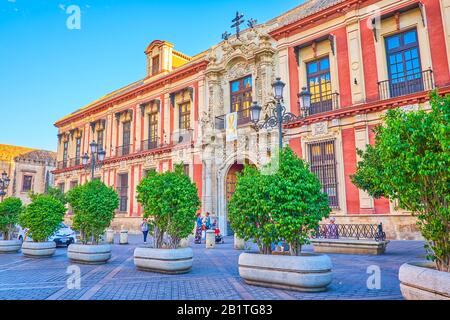 Sevilla, SPANIEN - 1. OKTOBER 2019: Die beeindruckende Fassade des Erzbischofspalastes mit geschnitztem Hauptportal auf der Plaza Virgen de los Reyes in Old to Stockfoto