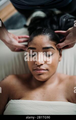afroamerikanische Frau erhält Kopfhaut Massage von Therapeuten Stockfoto