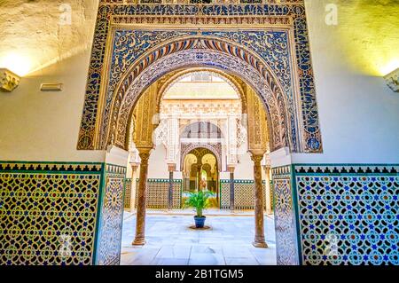 Sevilla, SPANIEN - 1. OKTOBER 2019: Der schön verzierte Bogenzugang zum mit farbenfrohem Putz verzierten Innenhof der Puppen auf October Stockfoto