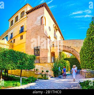 Sevilla, SPANIEN - 1. OKTOBER 2019: Die Seitenhöfe des Alcazar-Komplexes mit mittelalterlichen Wänden des Palastes mit bogenförmigem Passweg, am 1. Oktober in Sevill Stockfoto