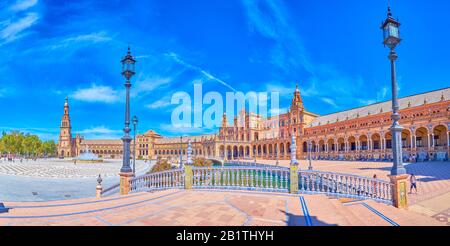 Sevilla, SPANIEN - 1. OKTOBER 2019: Panoramaaussicht auf die Brücke auf der Plaza de Espana mit ihren malerischen Keramikhandläufen und der großen Ziegelsteingalerie auf dem Bac Stockfoto