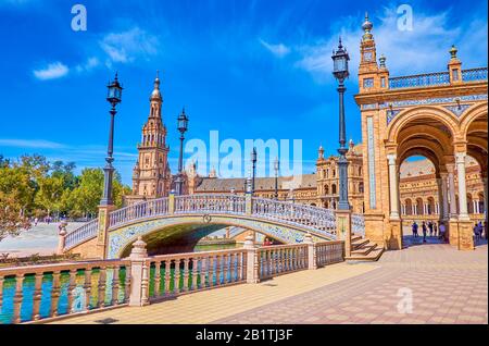 Sevilla, SPANIEN - 1. OKTOBER 2019: Die prächtige andalusische Architektur großer Ziegelsteingalerien und Brücken mit Fliesenverzierungen auf der Plaza de E Stockfoto