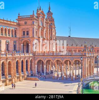 Sevilla, SPANIEN - 1. OKTOBER 2019: Die überdachte Balustrade auf dem zentralen Balkon der Galerie auf der Plaza de Espana ist voller Touristen, die auf der Tribüne zuschauen Stockfoto