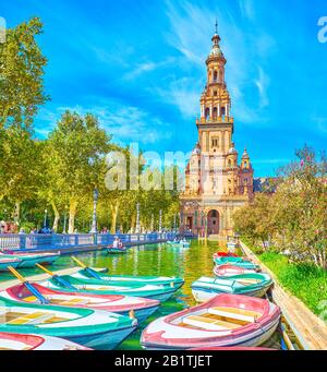 Sevilla, SPANIEN - 1. OKTOBER 2019: Die Touristen mieten Boote für die Freizeit, die auf dem Kanal auf der Plaza de Espana, 1. Oktober in Sevilla unterwegs sind Stockfoto