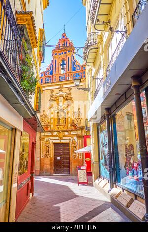 Sevilla, SPANIEN - 1. OKTOBER 2019: Die kleine Kapelle von San Jose mit Fassade im Stil des Barock ist in engen mittelalterlichen Gassen zwischen Hochhäusern versteckt Stockfoto
