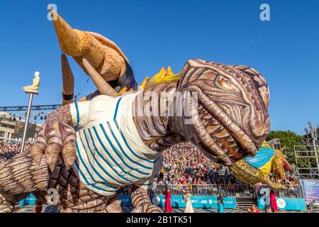 Nice, Cote d'Azur, Frankreich - 15. Februar 2020: Carnaval de Nice, Dieses Jahr Thema King of Fashion - lächelnder Dinosaurierballon mit Darstellern Stockfoto