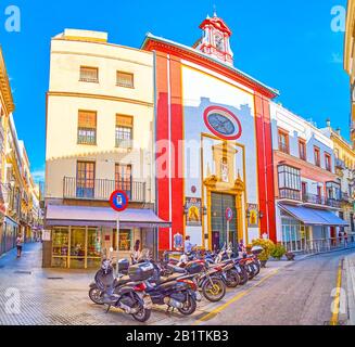 Sevilla, SPANIEN - 1. OKTOBER 2019: Die kleine Calle Orfila mit geparkten Fahrrädern und der mittelalterlichen Capilla de San Andres, am 1. Oktober in Sevilla Stockfoto