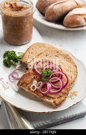 Brot mit Schweinebrot gemischt mit gemahlenen Knistern auf einem weißen Teller Stockfoto