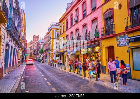 Sevilla, SPANIEN - 1. OKTOBER 2019: Die Warteschlange an der Bushaltestelle in der engen Straße in der historischen Nachbarschaft von Sevilla, am 1. Oktober in Sevilla Stockfoto