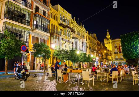 Sevilla, SPANIEN - 1. OKTOBER 2019: Angenehme spanische Nächte sind die beste Zeit für einen Besuch von Cafés im Freien, entspannen und genießen Sie das Gefühl des mittelalterlichen Sririt, Stockfoto