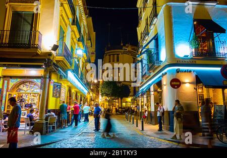 Sevilla, SPANIEN - 1. OKTOBER 2019: Die Nacht ist eine sehr überfüllte Zeit, Touristen und Einheimische gehen durch die Straßen und Cafés und Restaurants werden voll, auf Stockfoto