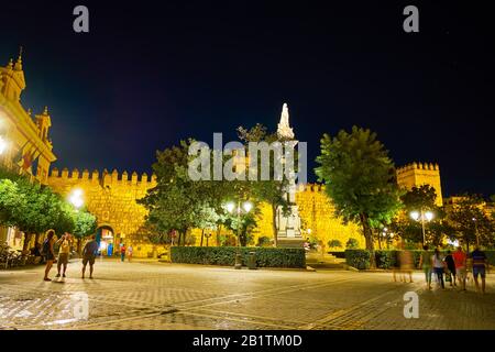 Sevilla, SPANIEN - 1. OKTOBER 2019: Die Menschen wandern nachts durch das historische Viertel und genießen eine helle Beleuchtung der mittelalterlichen Wahrzeichen, am 1. Oktober in Stockfoto