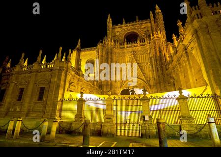 Schöne Puerta De San Cristobal von Sevilla Kathedrale mit großer Kanopie an den zentralen Türen in heller Nachtbeleuchtung, Spanien Stockfoto