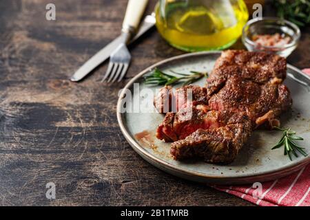 Frisch gegrilltes Steak aus Rindfleisch, Prime Black Angus Chuck, Rollsteak, in Stücke auf Gericht auf Holztisch geschnitten. Platz für Text Stockfoto