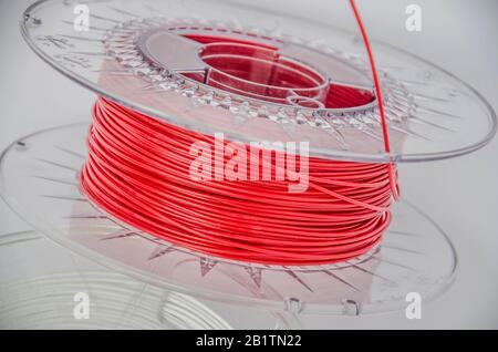 Nahansicht von Kunststoff für 3D-Druck. Roter Kunststofffilament, rote ABS/PLA-Spule für 3D-Drucker auf weißem Hintergrund, isoliert Stockfoto