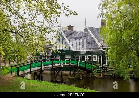 Traditionelle Fischerhäuser aus Holz, Kanal und Brücke, Nordholland, Niederlande. Blick auf die Straße und die traditionelle holländische Holzbrücke beim Angeln Stockfoto