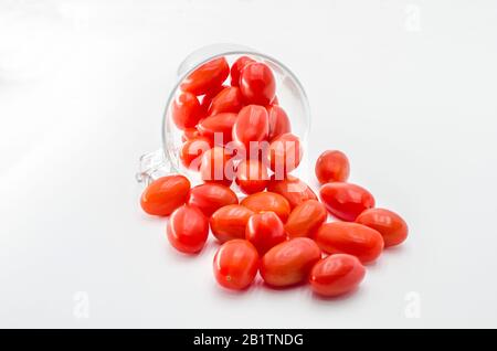 Kirschtomaten (Mini) im Glasbecher. Kirsch- oder Minitomaten aus Glas isoliert auf weißem Hintergrund Stockfoto