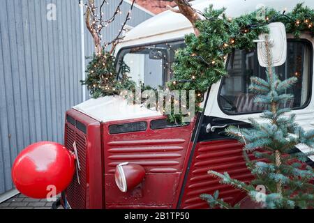 Riga, Lettland - 09. Dezember 2019. Altes Auto, seltener Citroen. Weihnachtsmarkt auf dem Kuppelplatz in der Altstadt. Handelshäuser mit Verkauf von weihnachtsgeschenken. Stockfoto