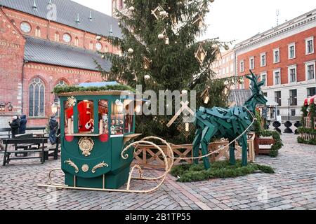 Riga, Lettland - 09. Dezember 2019. Weihnachtsmarkt auf dem Kuppelplatz in der Altstadt. Menschen, die traditionelle Souvenirs auf einem europäischen Weihnachtsmarkt kaufen Stockfoto