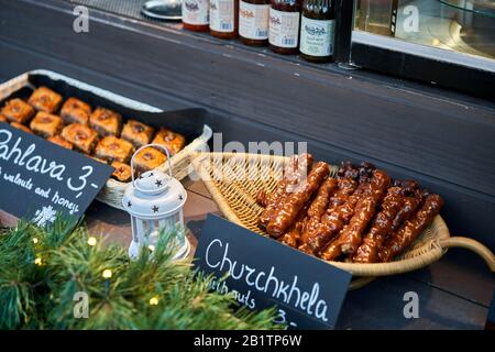 Riga, Lettland - 09. Dezember 2019. Georgisches Gericht. Tschurchkhela, Baklava und Desserts. Heißer Wein, Glühwein. Weihnachtsmarkt auf dem Kuppelplatz, in der Altstadt Stockfoto