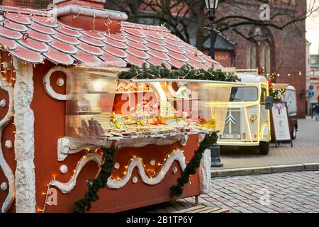 Riga, Lettland - 09. Dezember 2019. Weihnachtsmarkt auf dem Kuppelplatz in der Altstadt. Menschen, die traditionelle Souvenirs auf einem europäischen Weihnachtsmarkt kaufen Stockfoto