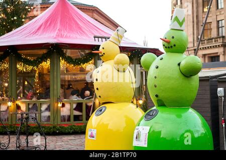 Riga, Lettland - 09. Dezember 2019. Recycling. Bunte Schneemänner, grün und gelb. Mülltonnen zur separaten Müllabfuhr in Form von Schneemänner Stockfoto