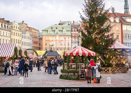 Riga, Lettland - 09. Dezember 2019. Weihnachtsmarkt auf dem Kuppelplatz in der Altstadt. Menschen, die traditionelle Souvenirs auf einem europäischen Weihnachtsmarkt kaufen Stockfoto