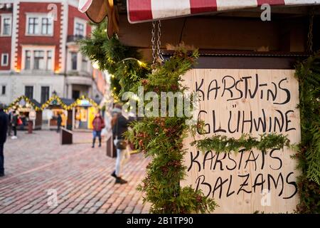 Riga, Lettland - 09. Dezember 2019. Weihnachtsmarkt auf dem Kuppelplatz in der Altstadt. Menschen, die traditionelle Souvenirs auf einem europäischen Weihnachtsmarkt kaufen Stockfoto