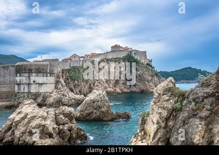 Blick auf die Mauern der Festung, die felsige Küste und das blaue Meer, Dubrovnik, Kroatien. Atemberaubender Blick auf die Stadtmauern von Dubrovnik und die Altstadt von Dubrovnik Stockfoto