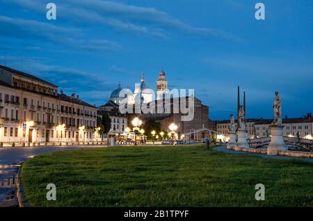 Die Statuen des Platzes von Prato della Valle in Padova nach Sonnenuntergang, Italien, nach Regen. Blick auf die Basilika am Prato della Valle in Padova bei Nacht Stockfoto