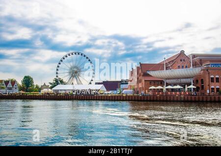 Danziger, Polen-August 2019: Blick auf die polnische Baltische Frederic Chopin Philharmonie, den Motlawa Fluss und das Riesenrad während des sonnigen Sommertags. Danziger Stockfoto