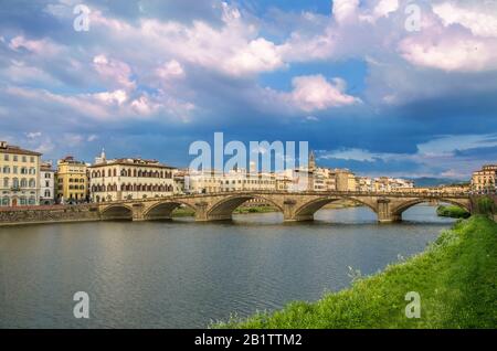 Blick auf die Brücke in Florenz bei Sonnenuntergang - Ponte alla Carraia, fünfbogenige Brücke über den Fluss Arno in der Region Toskana in Italien. Schönes Blau mit Stockfoto