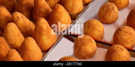 Gebratene gefüllte Reiskugeln mit dem Namen ARANCINO in italienischer Sprache werden am Lebensmittel-Verkaufsstand der Straße VERKAUFT Stockfoto