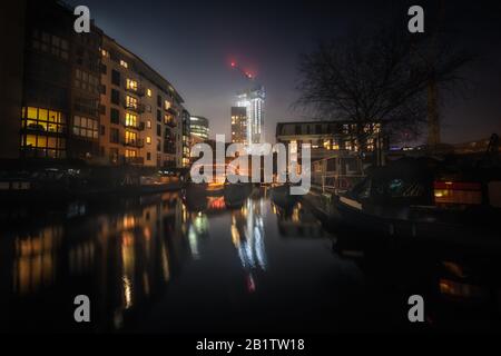 Nachtaufnahme von Sherborne Wharf in Birmingham, Großbritannien mit Lichtreflexionen im Kanalwasser Stockfoto